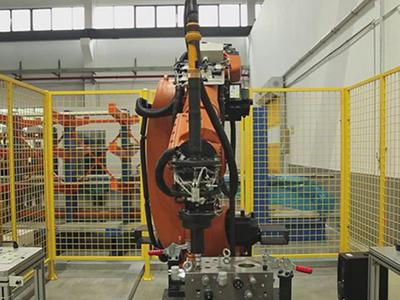 Hydraulic manifold being assembled by manipulator